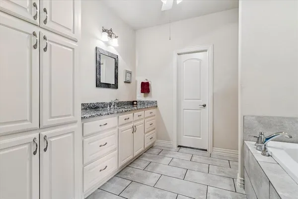 a spacious bathroom with a granite countertop sink a mirror and shower
