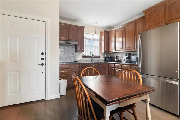 a kitchen with a table chairs refrigerator and cabinets