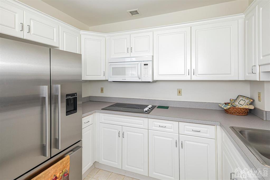 2423 Windrow Drive Plainsboro, NJ 08540 - Photo 11 of 36 a kitchen with stainless steel appliances granite countertop a sink and cabinets with wooden floor