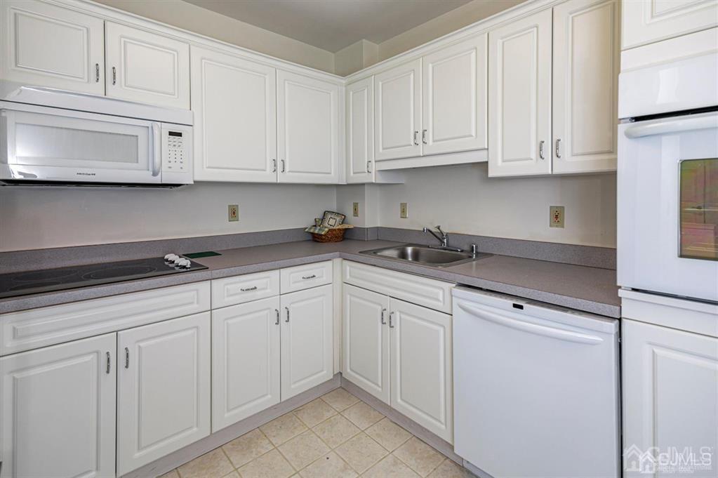 2423 Windrow Drive Plainsboro, NJ 08540 - Photo 12 of 36 a kitchen with white cabinets and white appliances