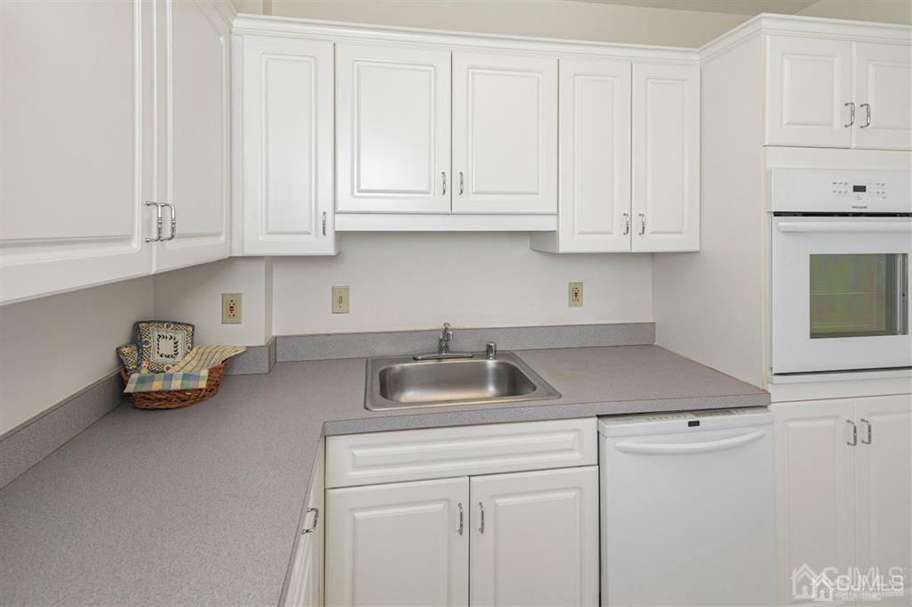 2423 Windrow Drive Plainsboro, NJ 08540 - Photo 13 of 36 a kitchen with white cabinets and a sink