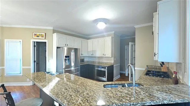 a kitchen with granite countertop a refrigerator and a sink