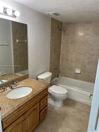 a bathroom with a granite countertop toilet a sink and a bathtub