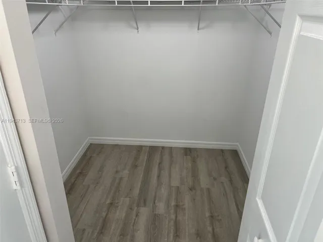 a view of walk in closet with wooden floor