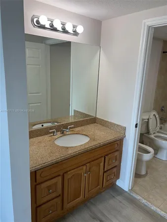 a bathroom with a granite countertop sink and a mirror