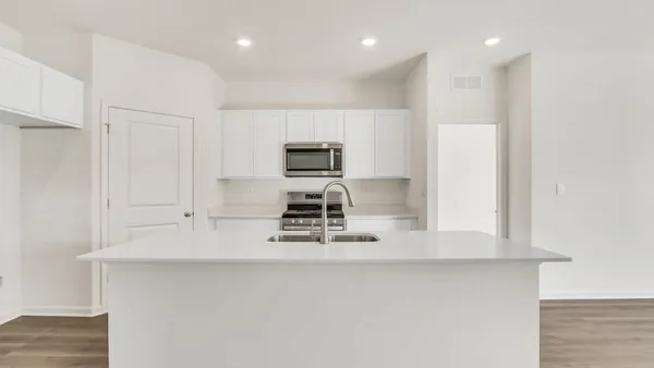 a kitchen with kitchen island white cabinets and stainless steel appliances