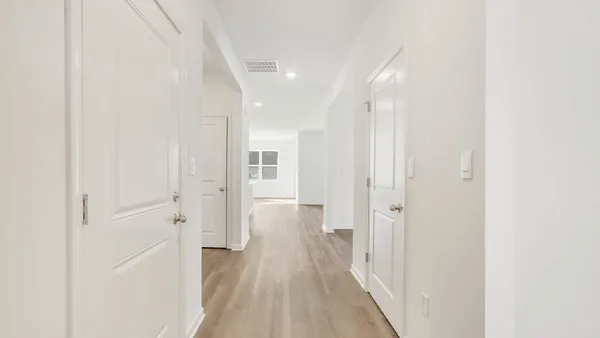a view of a hallway with wooden floor