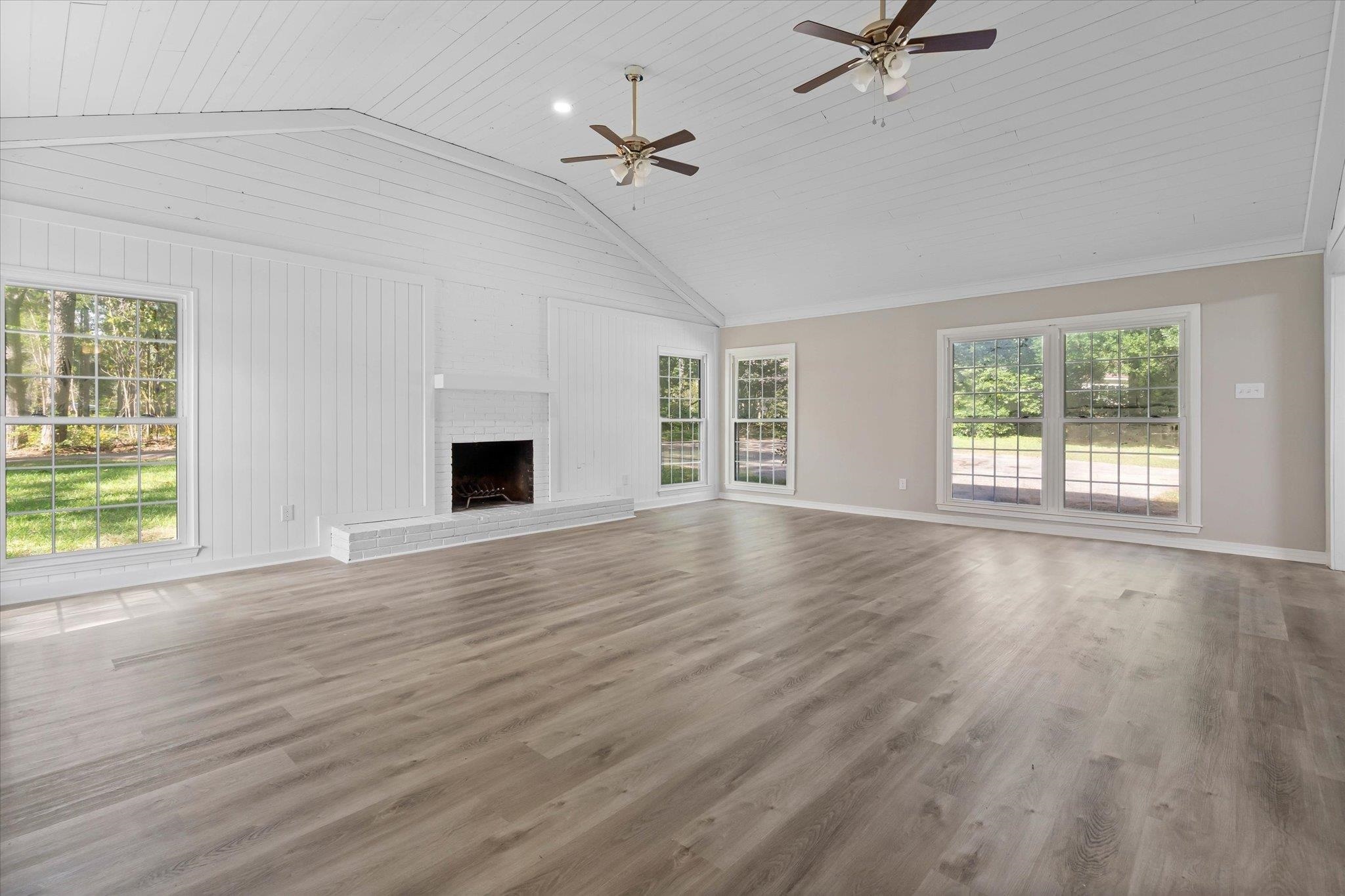 4700 Bit And Spur Road Mobile, AL 36608 - Photo 5 of 21 Unfurnished living room with lofted ceiling, wood finished floors, a ceiling fan, baseboards, and a fireplace
