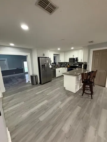 a large white kitchen with lots of counter space and stainless steel appliances