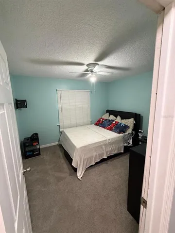 a spacious bedroom with a bed and a dresser
