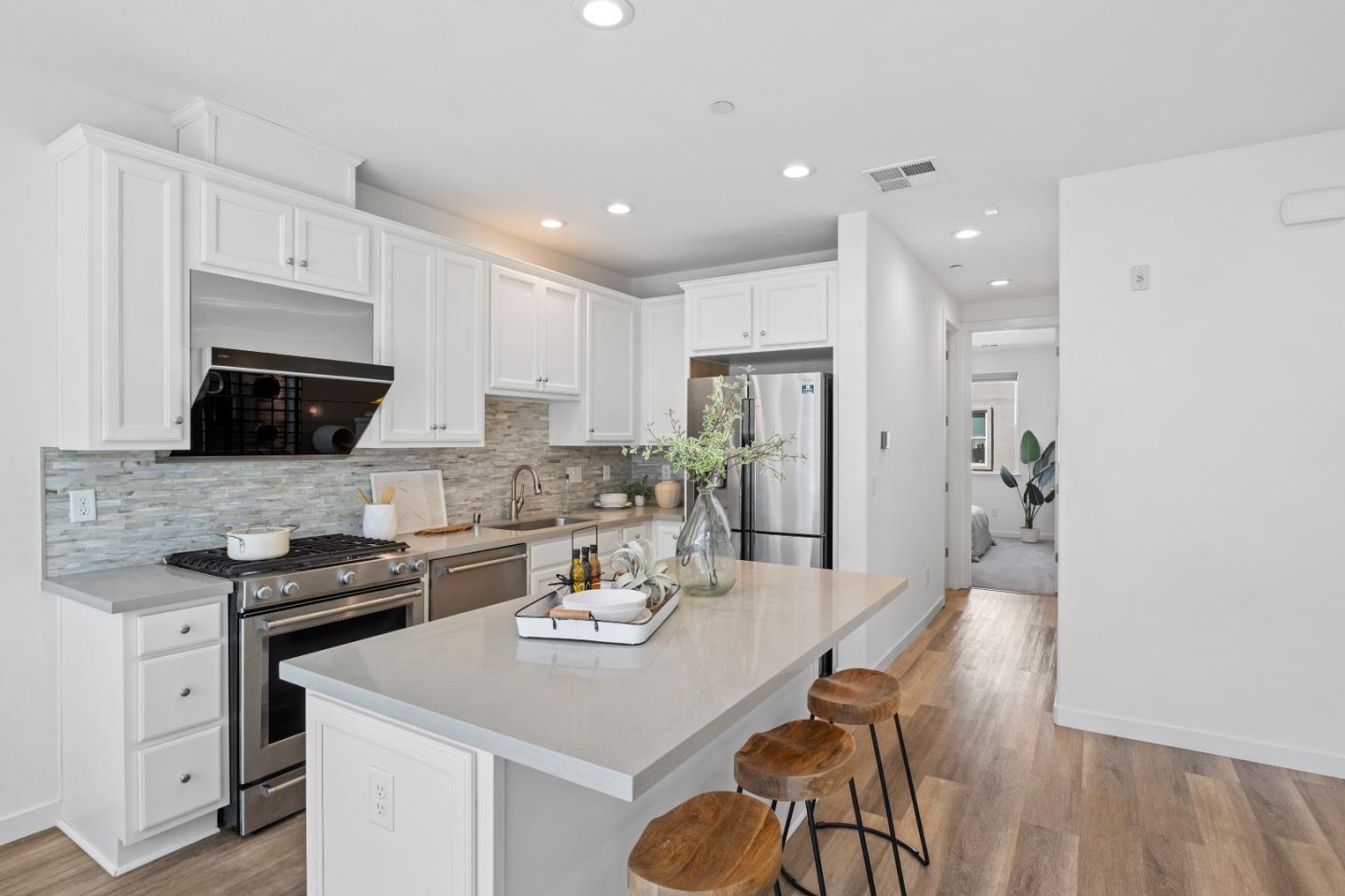 511 Sage Court Milpitas, CA 95035 - Photo 17 of 47 a kitchen with a sink a stove and chairs with wooden floor