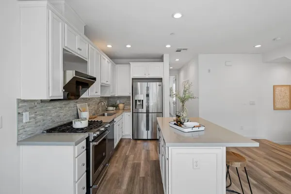 a kitchen with stainless steel appliances granite countertop a sink stove and refrigerator