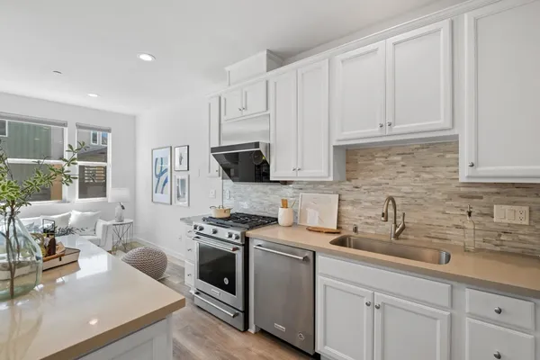 a kitchen with stainless steel appliances white cabinets and a sink