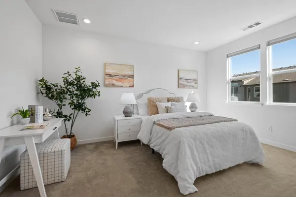 a bedroom with bed and a potted plant