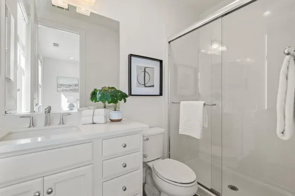 a bathroom with a granite countertop sink a toilet and shower