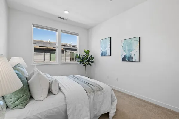 a bedroom with a bed and a painting on the wall