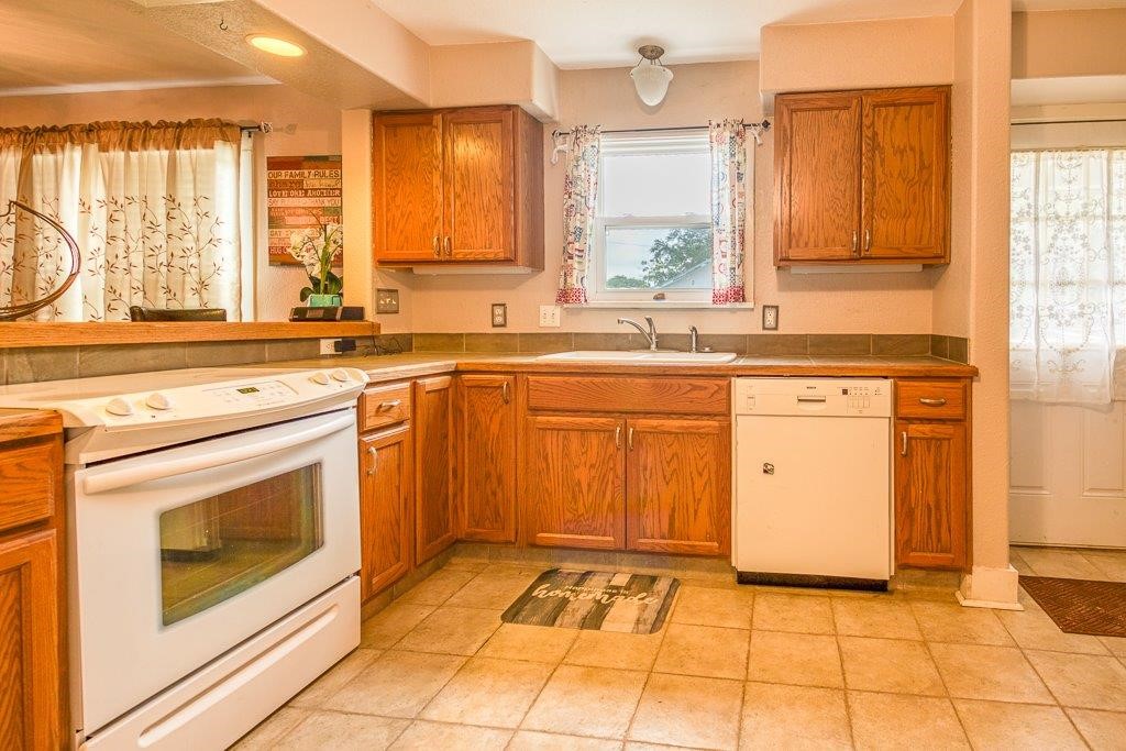 322 Fetick Avenue Taft, TX 78390 - Photo 20 of 34 a kitchen with a stove sink and cabinets