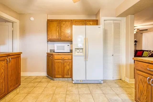 a view of a kitchen with refrigerator and wooden floor