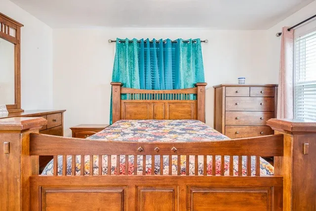 a bedroom with a bed and a window