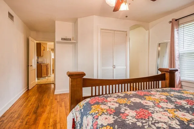 a bedroom with a bed and wooden floor