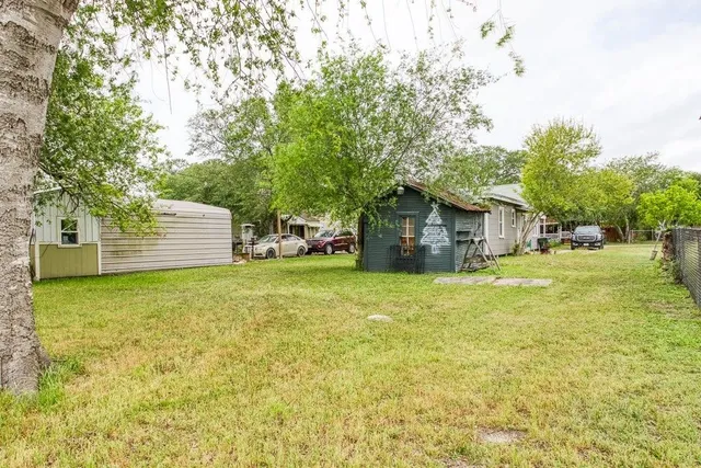 a view of a house with backyard and tree
