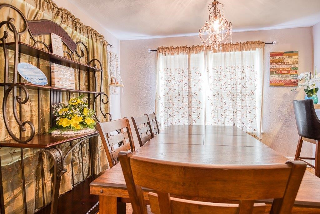 322 Fetick Avenue Taft, TX 78390 - Photo 9 of 34 a dining room with furniture a chandelier and wooden floor