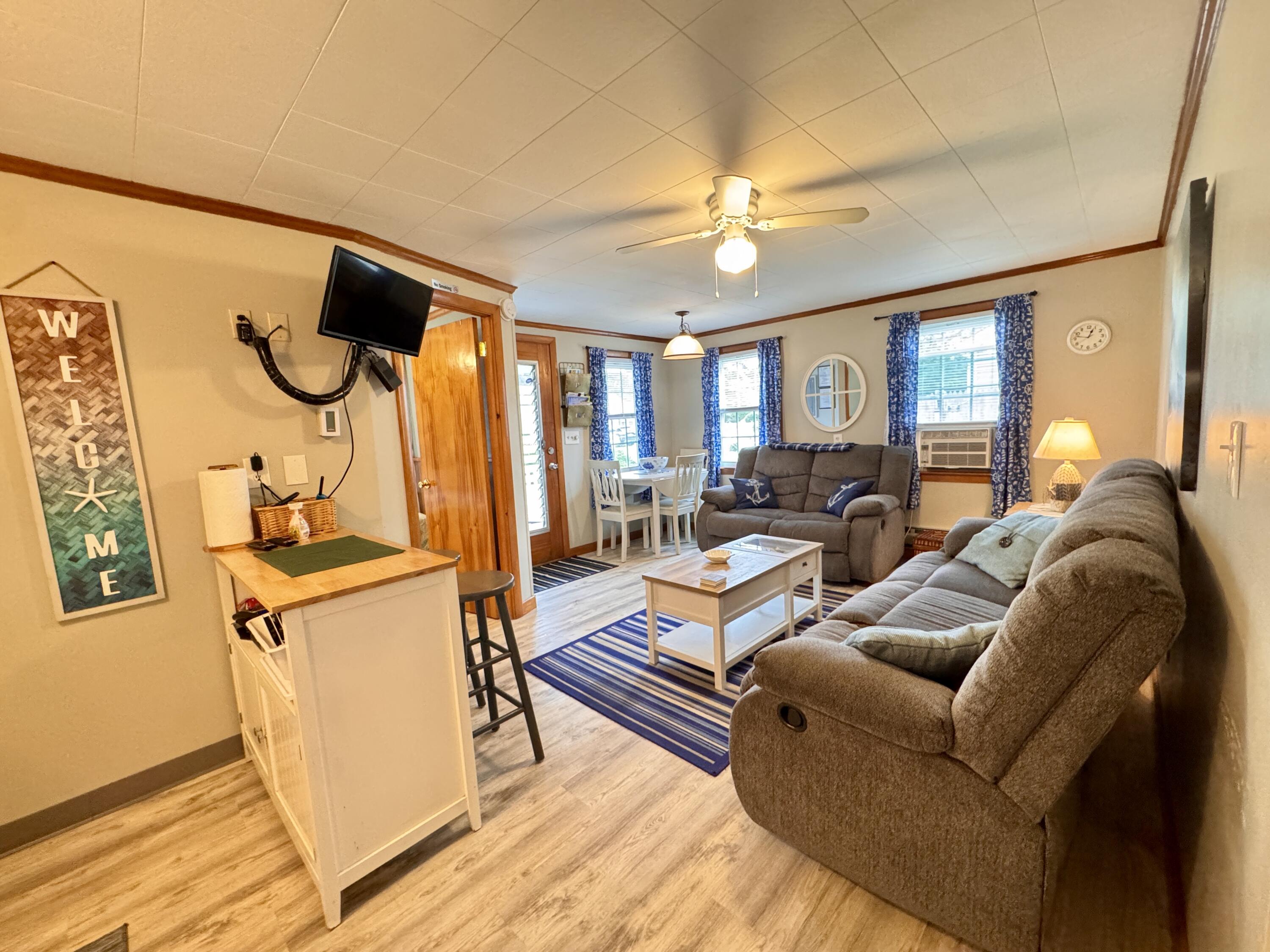 56-58 Uncle Rolf Road Dennis Port, MA 02639 - Photo 14 of 44 a living room with furniture and a chandelier