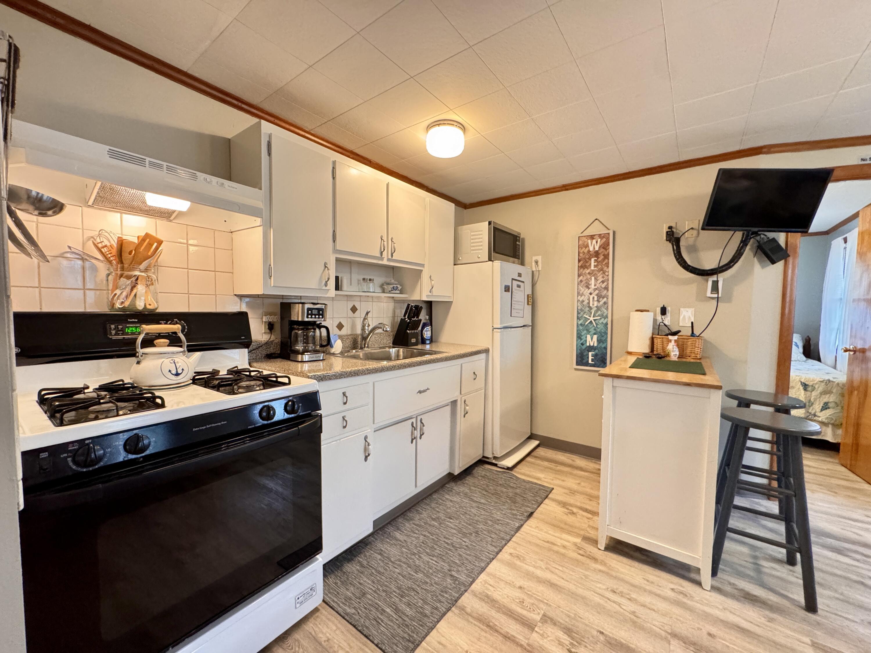 56-58 Uncle Rolf Road Dennis Port, MA 02639 - Photo 15 of 44 a kitchen with a stove a sink and a refrigerator