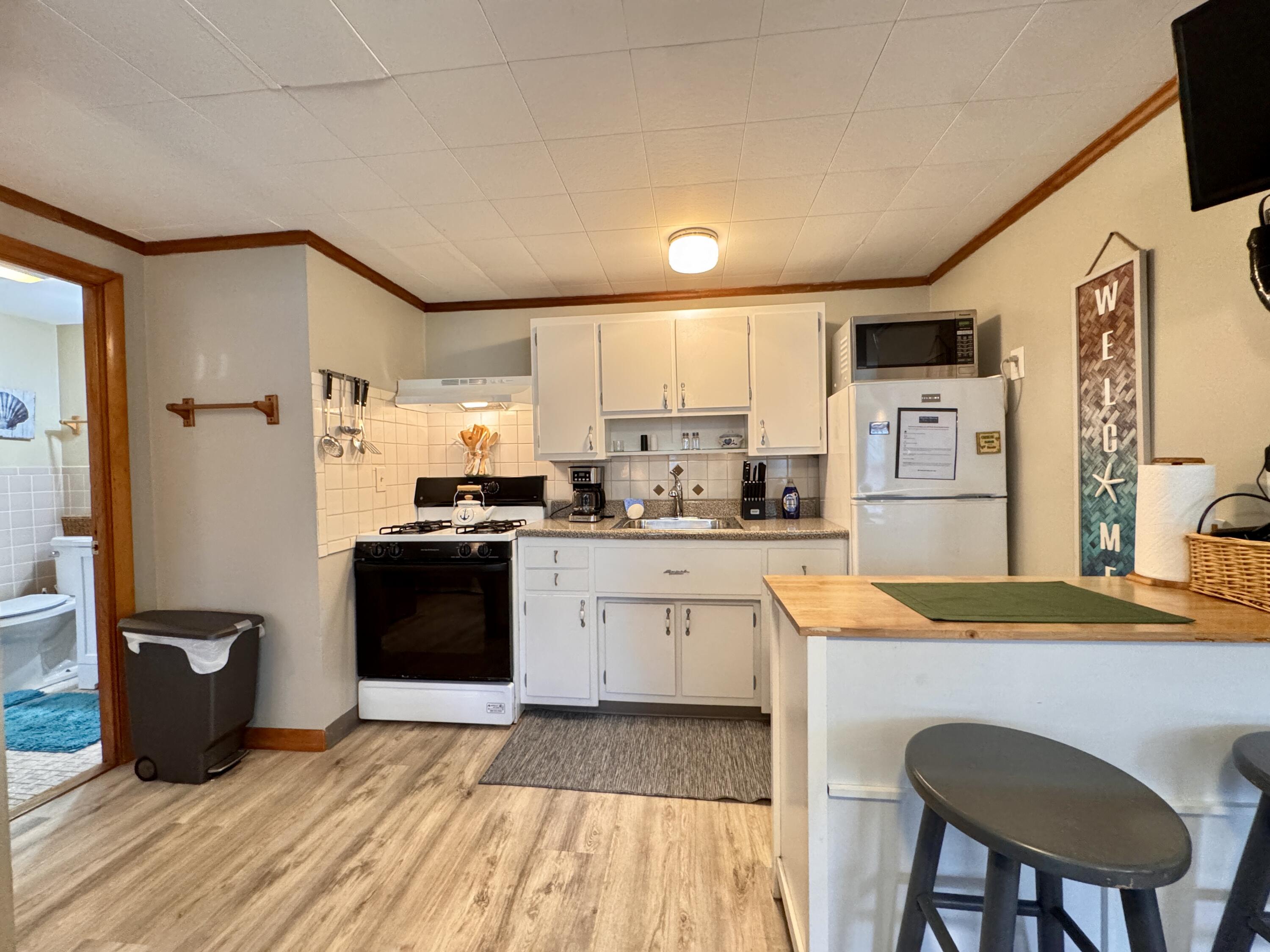 56-58 Uncle Rolf Road Dennis Port, MA 02639 - Photo 16 of 44 a kitchen with stainless steel appliances granite countertop a refrigerator a stove and a sink with wooden floor