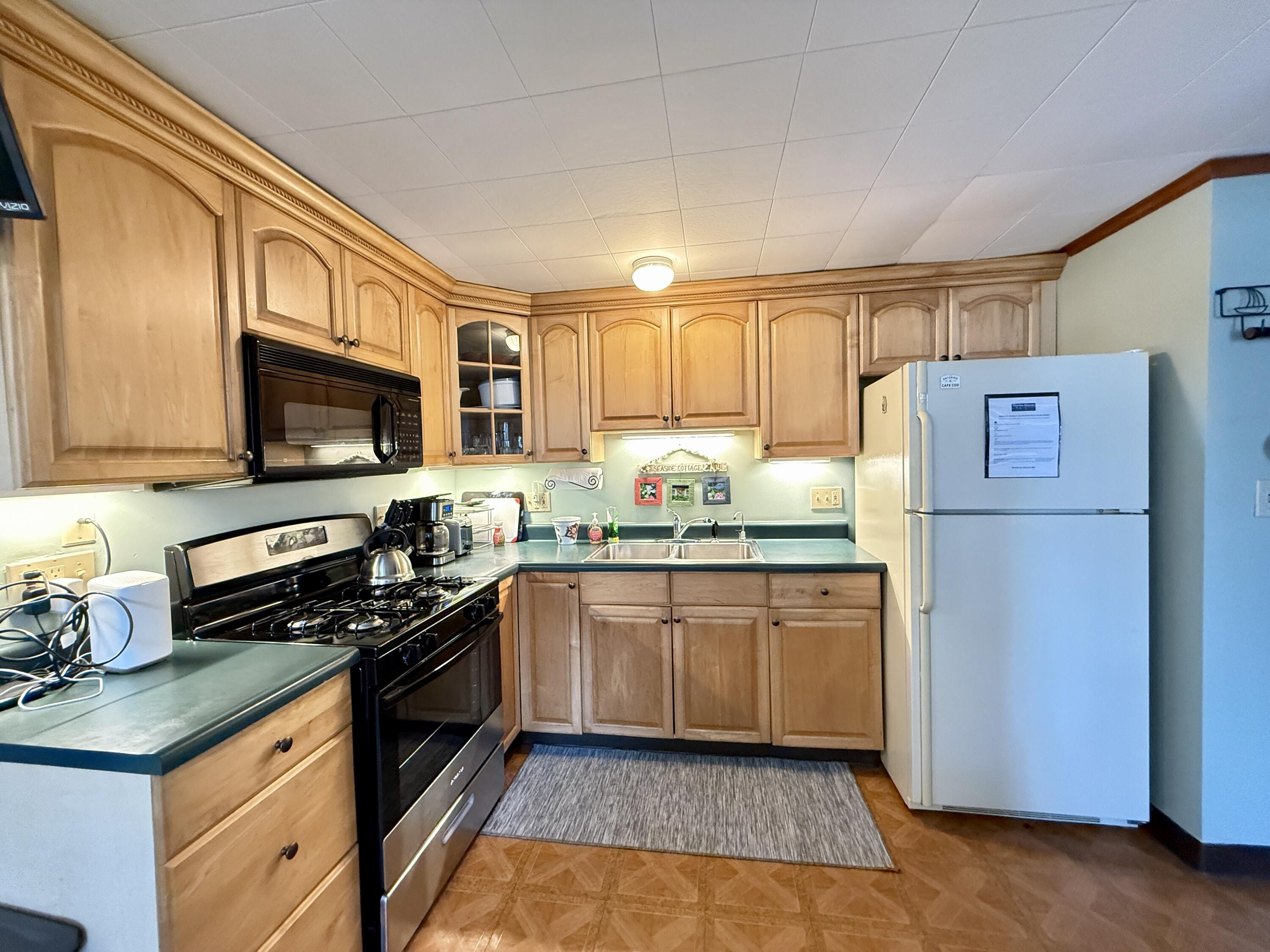 56-58 Uncle Rolf Road Dennis Port, MA 02639 - Photo 28 of 44 a kitchen with stainless steel appliances granite countertop a refrigerator stove microwave and sink