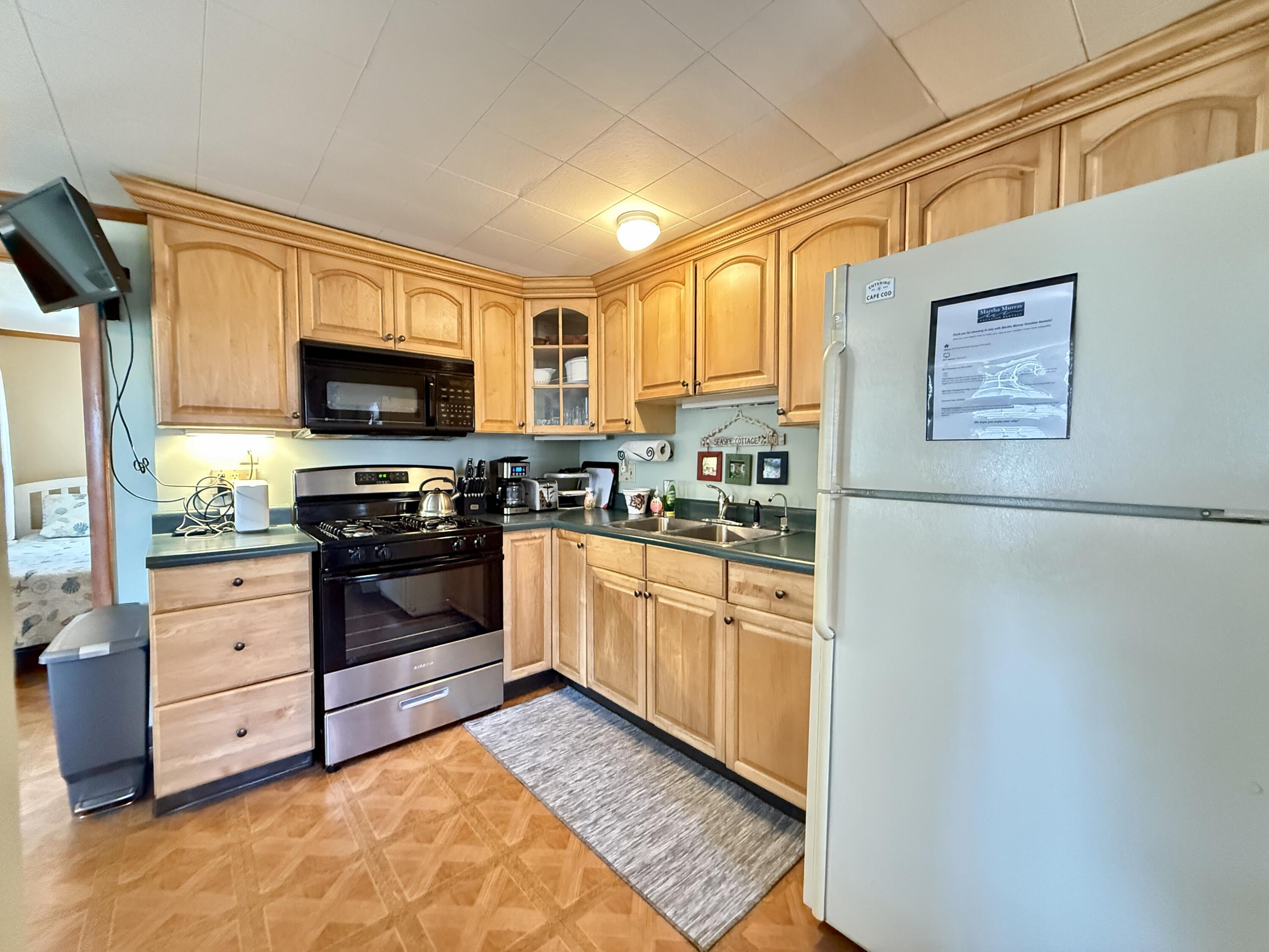 56-58 Uncle Rolf Road Dennis Port, MA 02639 - Photo 29 of 44 a kitchen with stainless steel appliances a stove a microwave and a refrigerator