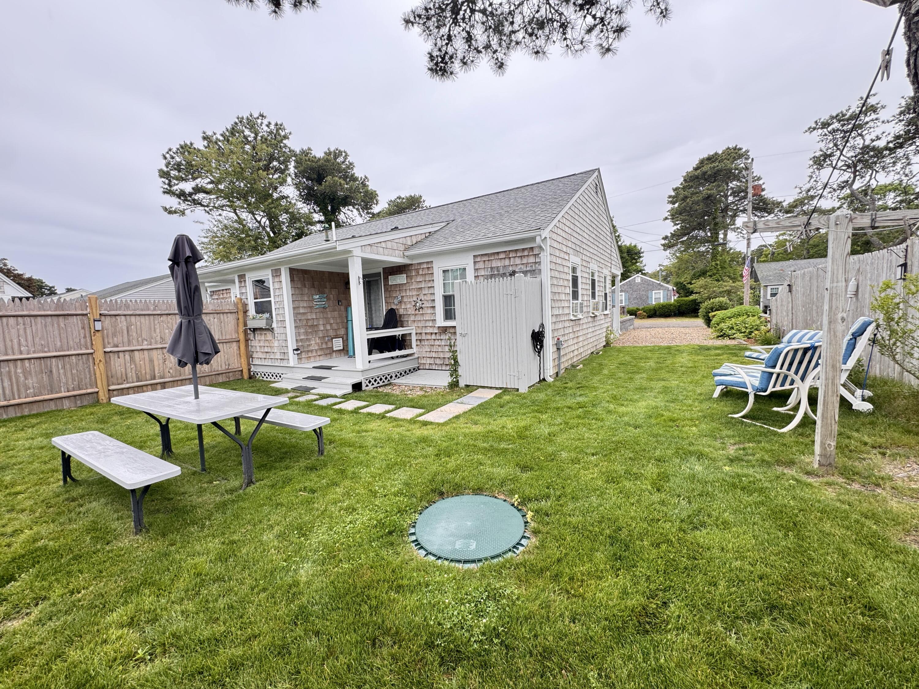 56-58 Uncle Rolf Road Dennis Port, MA 02639 - Photo 3 of 44 a backyard of a house with table and chairs