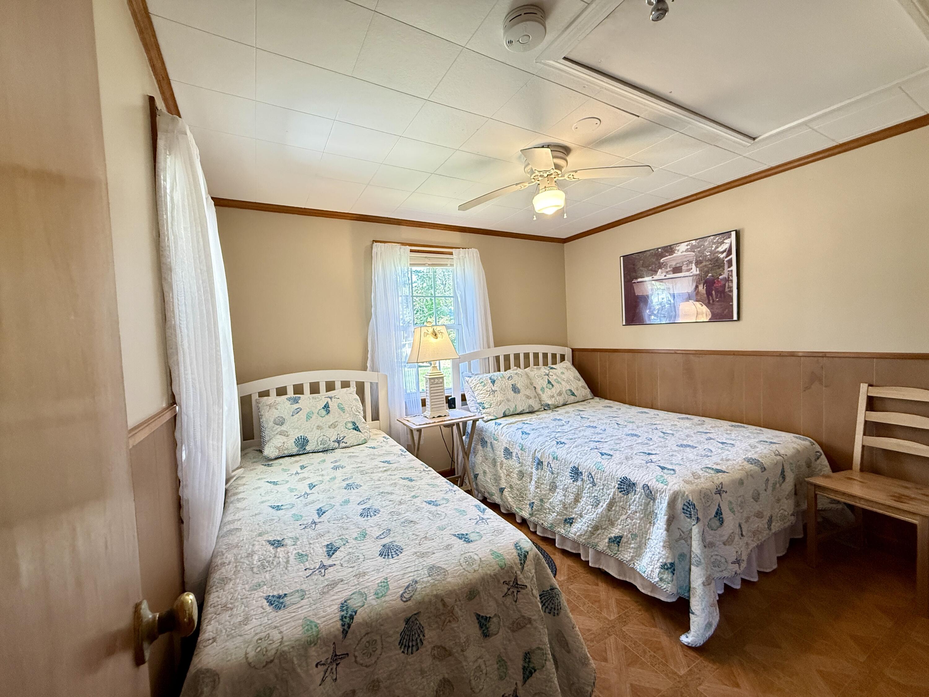 56-58 Uncle Rolf Road Dennis Port, MA 02639 - Photo 32 of 44 a bedroom with two beds and a chandelier