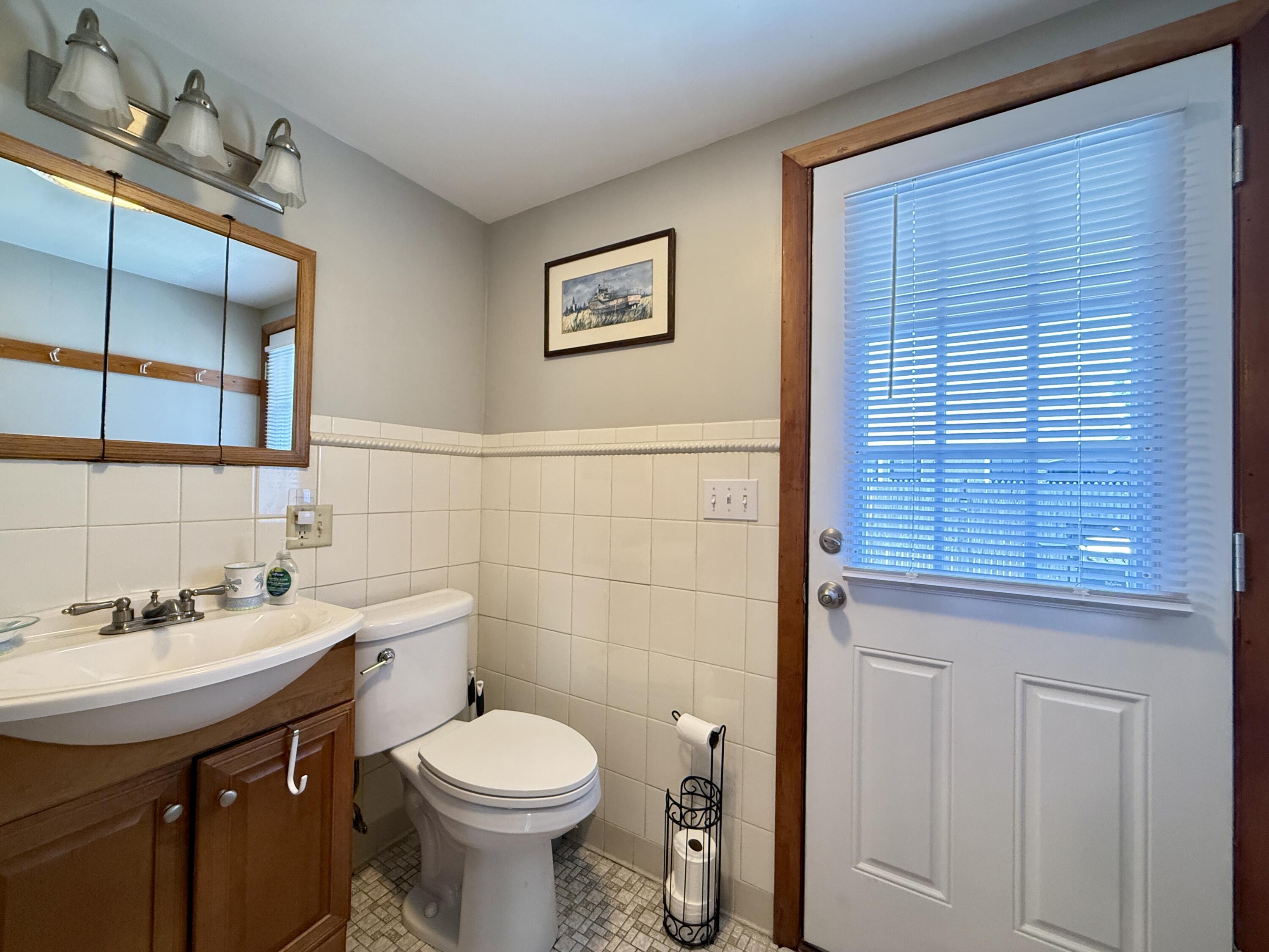 56-58 Uncle Rolf Road Dennis Port, MA 02639 - Photo 36 of 44 a bathroom with a toilet a sink and mirror