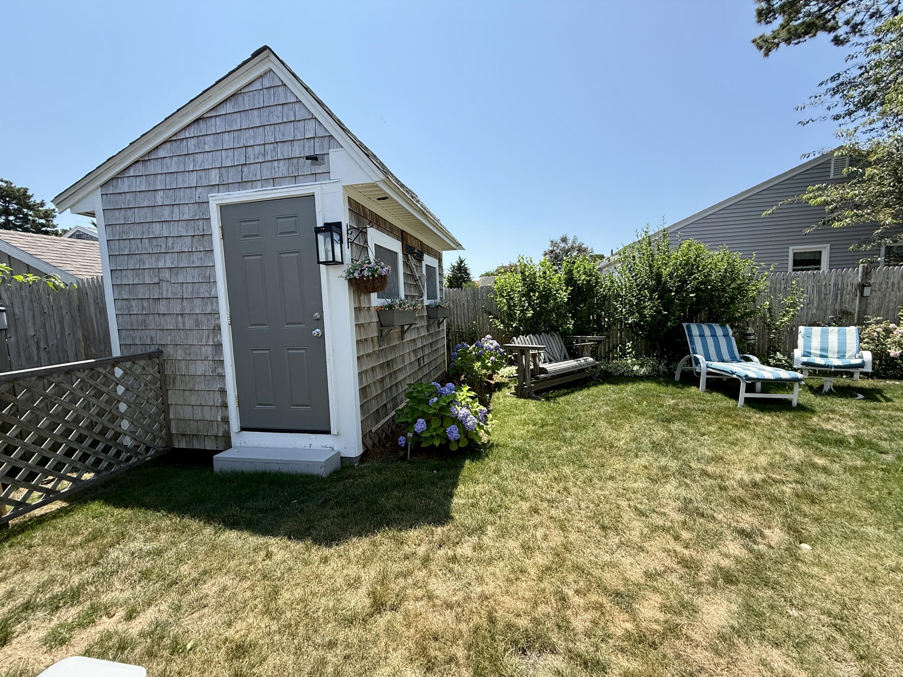 56-58 Uncle Rolf Road Dennis Port, MA 02639 - Photo 40 of 44 a view of a house with backyard and sitting area