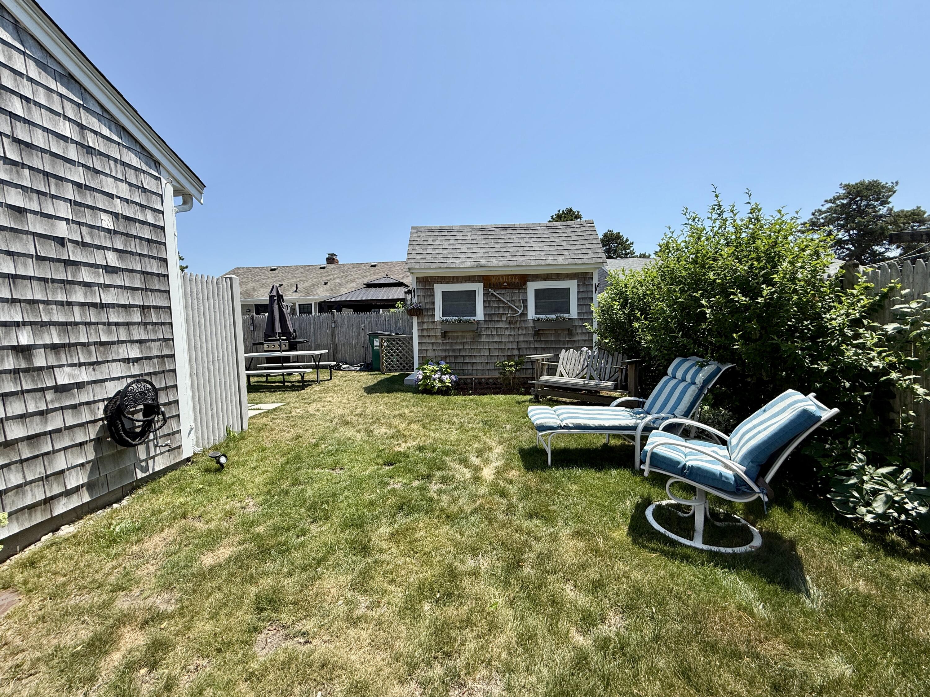 56-58 Uncle Rolf Road Dennis Port, MA 02639 - Photo 9 of 44 a view of a house with a patio and a yard