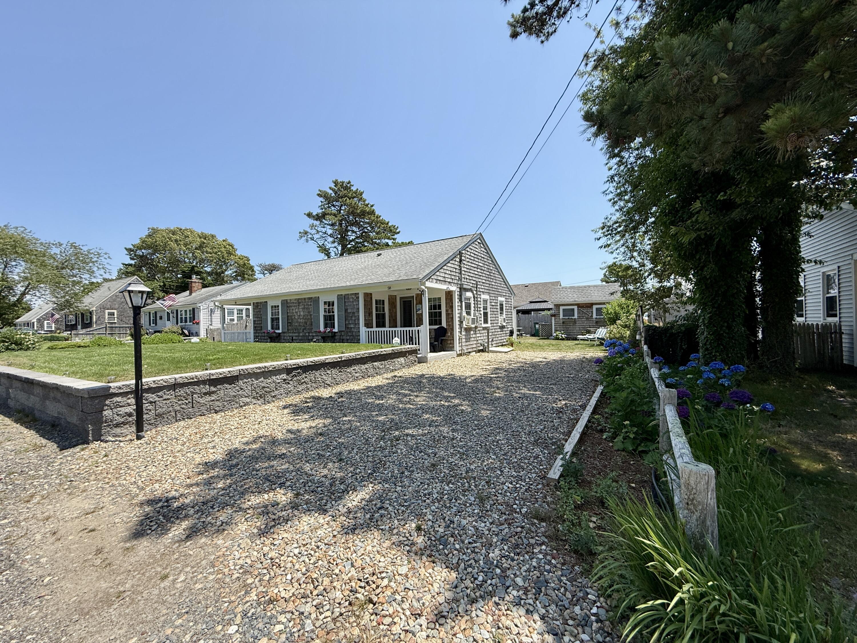 56-58 Uncle Rolf Road Dennis Port, MA 02639 - Photo 10 of 44 a front view of a house with a yard