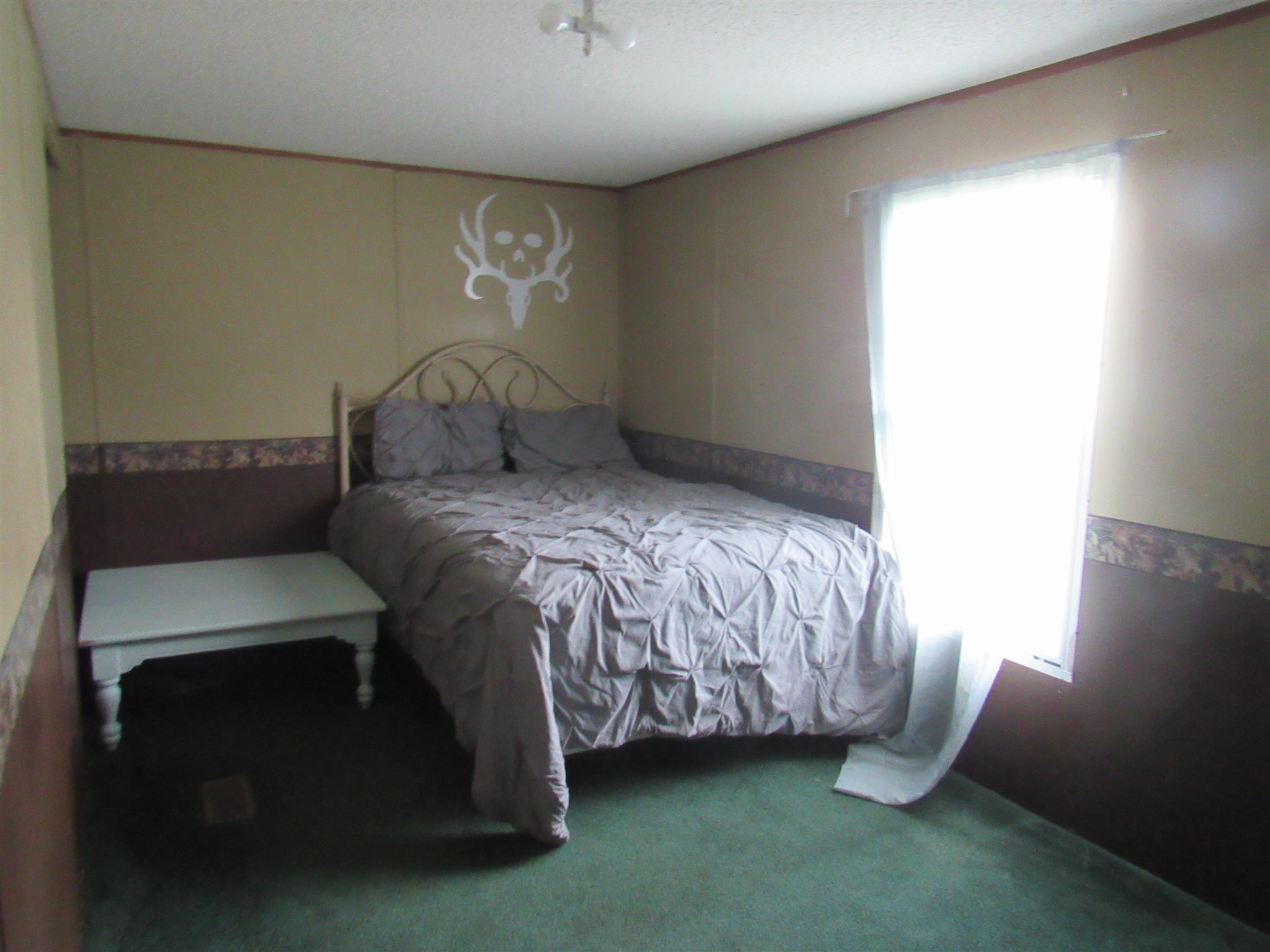 2050 CCC Road McEwen, TN 37101 - Photo 8 of 16 a bed sitting in a bedroom next to a window