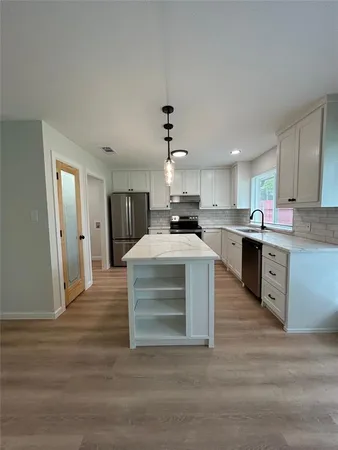 a kitchen with stainless steel appliances kitchen island wooden cabinets and granite counter tops