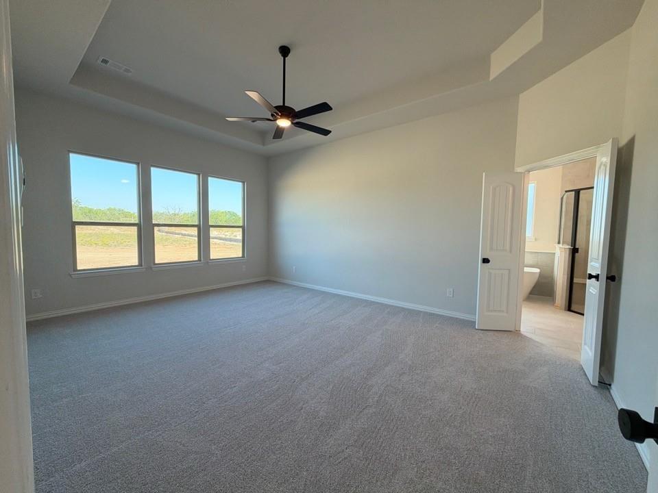 313 Johnny Boy Way Springtown, TX 76082 - Photo 7 of 11 Recessed ceiling with a contemporary ceiling fan, light gray carpeting, and a series of three windows
