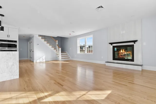 a view of empty room with wooden floor and fireplace