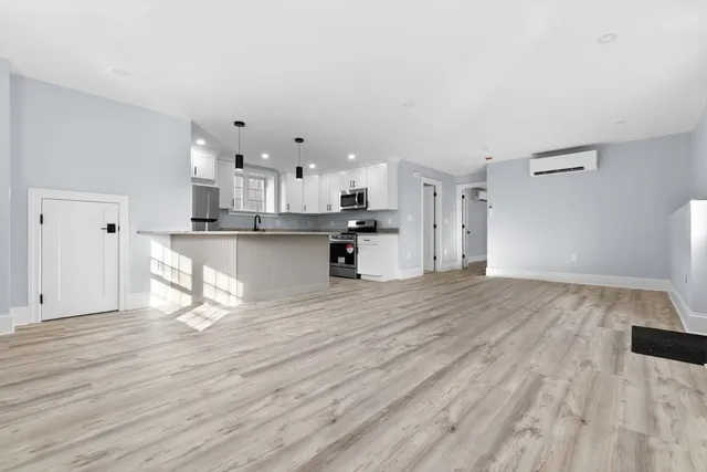 a kitchen with granite countertop a sink a center island stainless steel appliances and cabinets