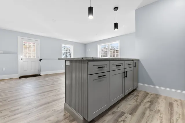 a kitchen with granite countertop white cabinets and refrigerator