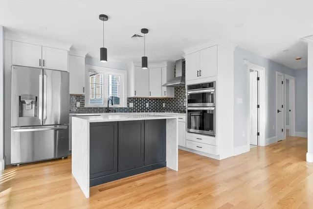 a kitchen with stainless steel appliances granite countertop a refrigerator and a sink