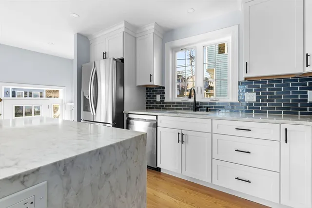 a kitchen with granite countertop a sink stainless steel appliances and cabinets