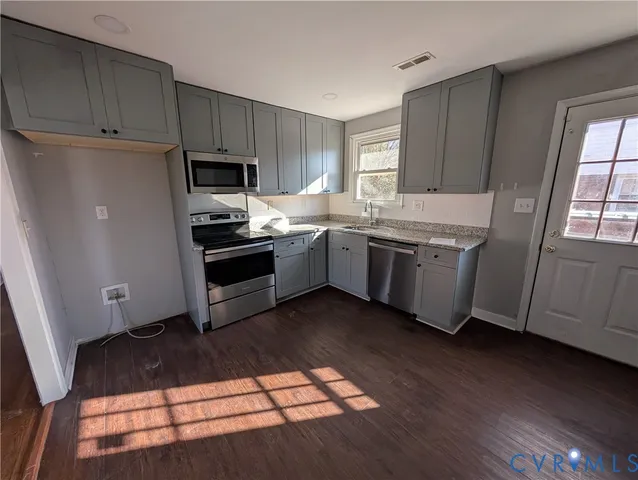 a kitchen with stainless steel appliances granite countertop a stove a sink and a refrigerator