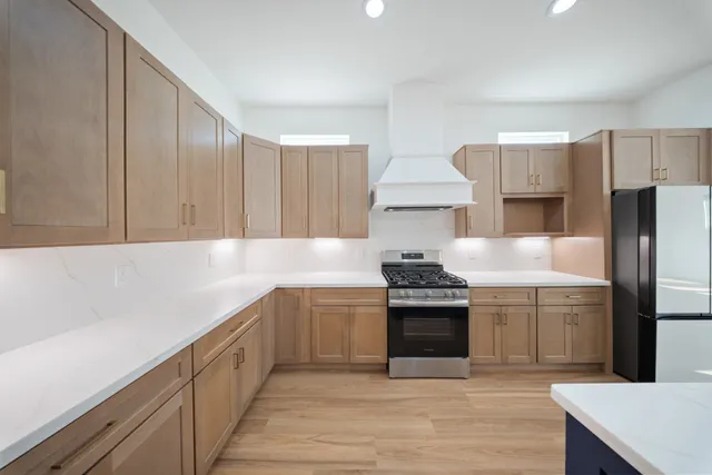 a kitchen with stainless steel appliances granite countertop a sink stove and refrigerator