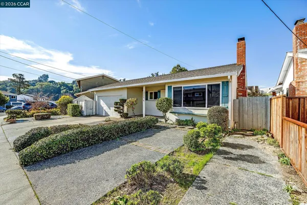 a front view of a house with a garden and outdoor seating