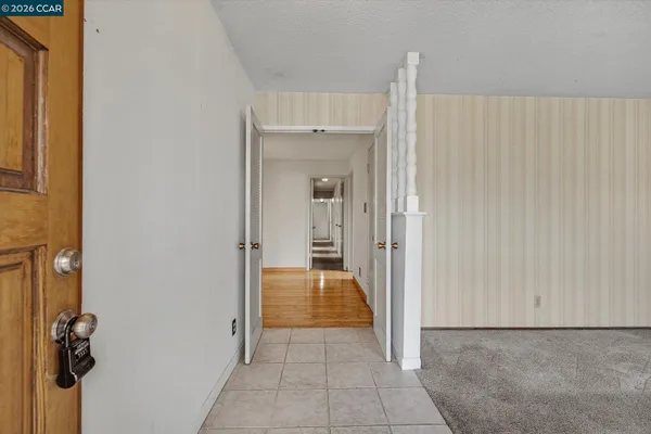 a view of a hallway to rooms and stairs