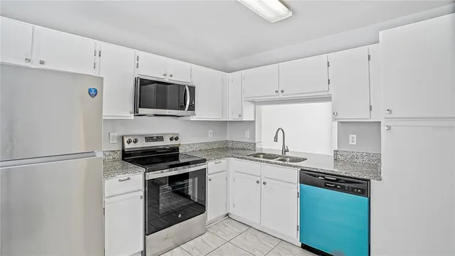 a kitchen with cabinets stainless steel appliances and sink